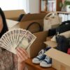 物を売って現金を持つ女性
