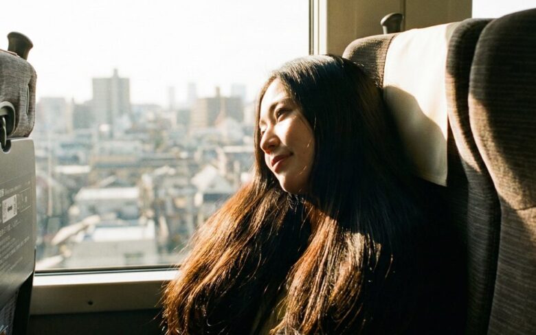 電車に乗って上京する女性