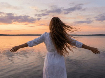 湖畔で両手を広げる女性